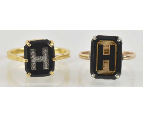 A yellow metal and onyx set 'H' ring, size M, and a yellow metal and onyx set ring, also inscribed 'H', size K, combined appr