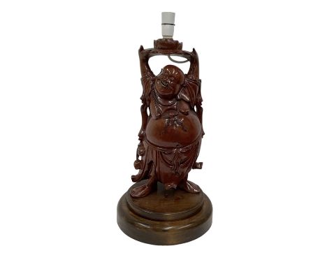 A Chinese carved hardwood figural table lamp modelled as laughing Buddha, height to top of fitment 56cm.
