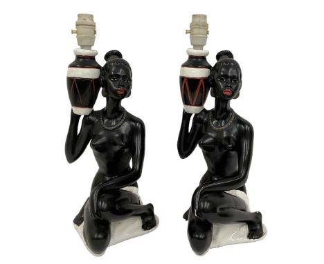 A pair of 1950s plaster lamp bases modelled as African ladies, height to top of fitment 37.5cm.