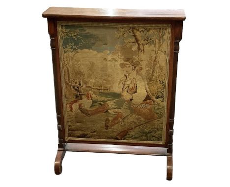 A 19th century mahogany framed tapestry firescreen, depicting a shepherd sitting beside a lake with his dog, height 75.5cm, w
