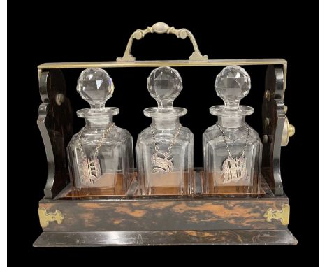 An early 20th century coromandel tantalus, 'Presented to John A Forest by Merchistonians on the 24th July 1900', with three c