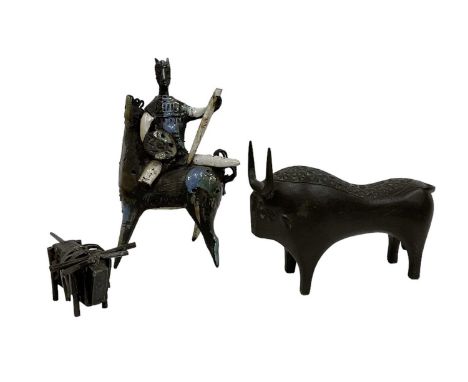 A 20th century bronze model of a stylised bull, with impressed star-form decoration, height 18.5cm, a smaller metal model of 