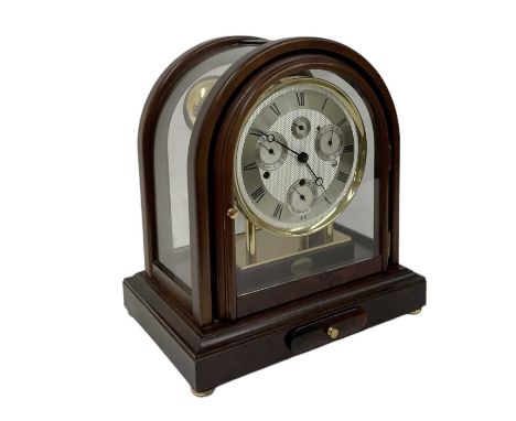 THE GREENWICH CLOCK CO; a reproduction mahogany cased chiming mantel clock with dome top, the silvered dial set with Roman nu