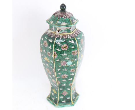 A Chinese famille verte green ground hexagonal baluster vase and cover, Kangxi Period, prunus and lotus petal decoration, hei