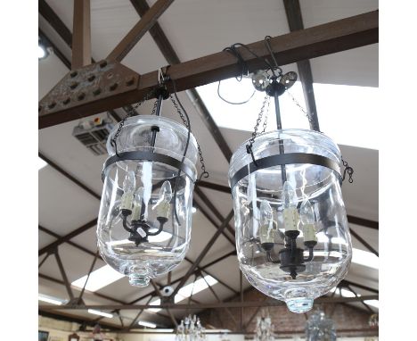 A pair of hanging glass light fittings, with wrought-metal mounts, diameter 22cm 