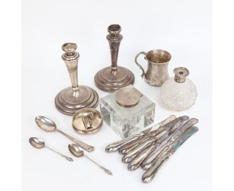 A box of silverware, to include a pair of candlesticks, a christening mug, a silver-mounted inkwell, tea knives etc 