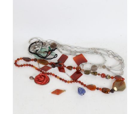 A box containing Chinese jade disc pendant, a silver and coral rose design pendant, and other hardstone set jewellery 