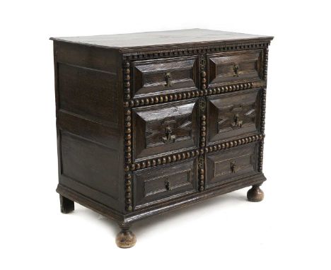 A Carolean style oak chest of drawers c,1880, with haped panelled drawer fronts, brass drop handles and bobbin moulded decora