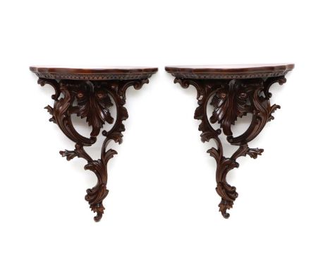 A pair of carved mahogany wall brackets, 20th century in the Chippendale manner, of cartouche form with leaf decoration 34cm 