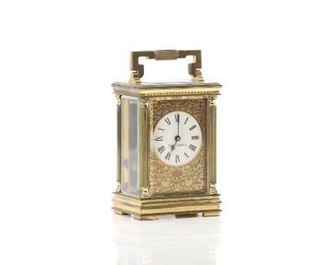 A Mappin and Webb brass carriage clock 20th Century, with decorative foliate dial and pillaster column supports, in original 