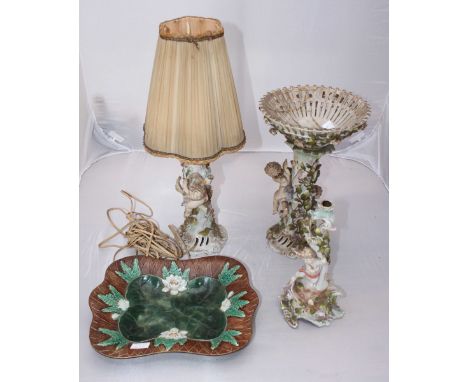SECTION 29. A German porcelain lamp decorated with moulded cherubs and flowers, together with a similar decorated candlestick