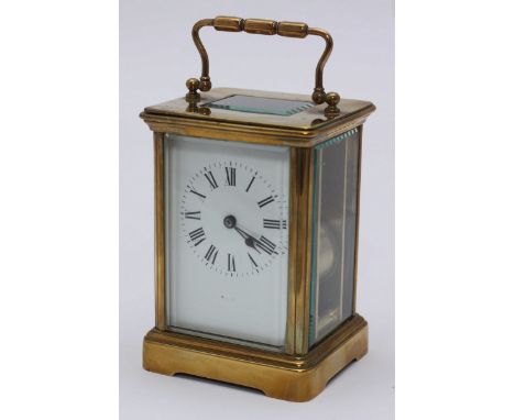 A French brass cased carriage clock with white dial, black Roman numerals, four bevelled glass panels with additional bevelle