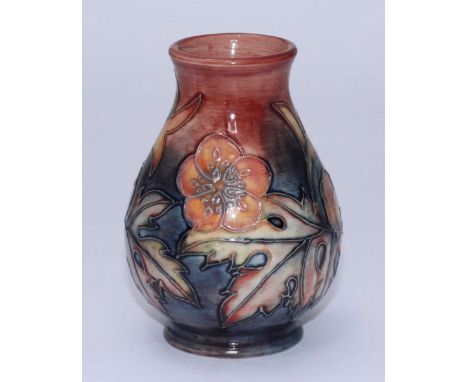 A Moorcroft pottery vase in a pink and peach floral pattern with leaves, to a pastel red and blue ground, of bulbous form, da