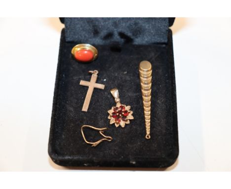 A 9ct gold crucifix pendant; a 9ct gold pendant set with red stone; a yellow metal pendant; and an 18ct gold and coral set si