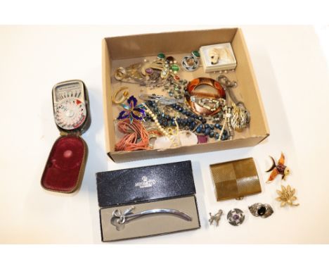 A box containing various costume jewellery, a compact, light meter etc.