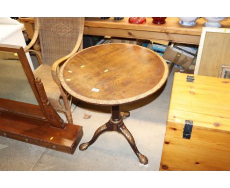 A mahogany and gilt decorated tripod circular topped table 