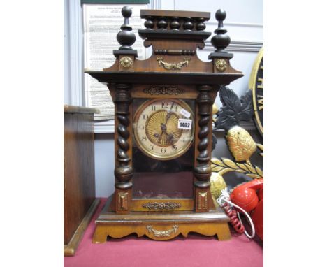 A XIX Century German Walnut Mantel Clock , the pediment with turned finials, glazed door to circular dial, on a shaped base w