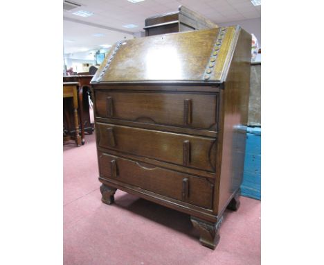 A 1930's Oak Bureau, with fall front, fitted interior, over three drawers in bracket feet.
