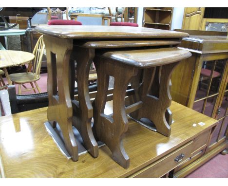Ercol Nest of Three Coffee Tables, with rounded corners to rectangular tops on openwork supports, labelled.