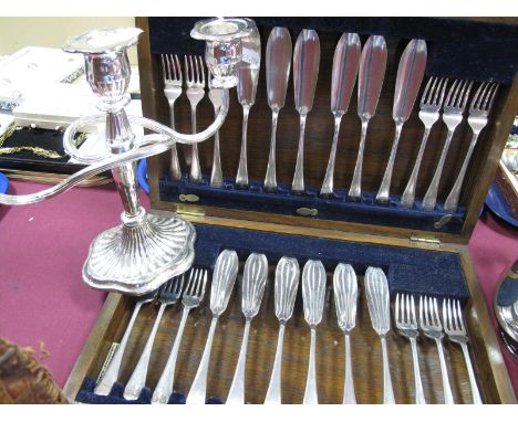 A Wooden Cased Set of Twelve Fish Knives and Forks, initialled; together with a three light twin branch candelabrum. (2)
