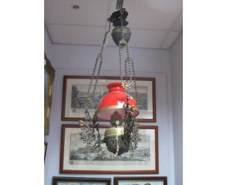 An Ornate Hanging Ceiling Oil Lamp, with weighted baluster, pierced support to red glass shade.