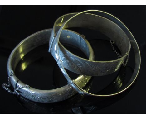 Two silver stiff hinge bangles and a silver bangle