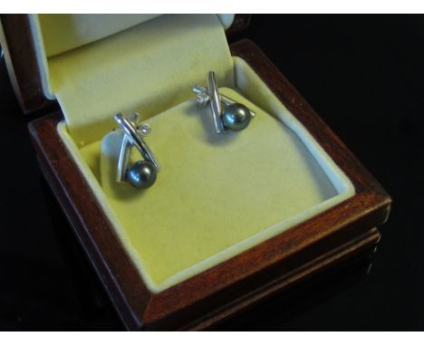A pair of white gold earrings the kiss shaped polished and frosted gold front set with a single grey cultured pearl and 0.10c