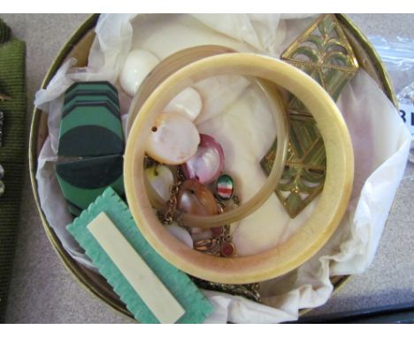 A tub of bijouterie including horn bangle, Art Deco scarf clip etc