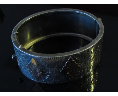 A silver bangle with engraved detail and rose gold decoration, 32.9g