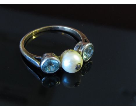 A pearl dress ring flanked by two bezel set stones, size O