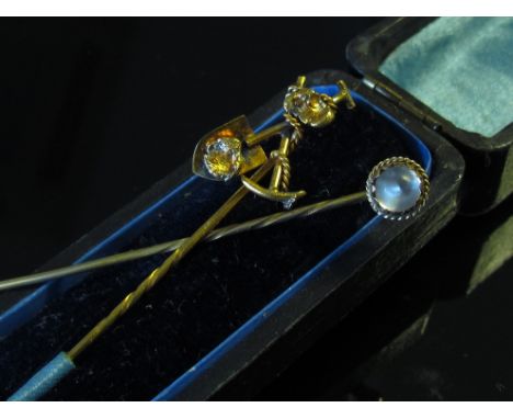 A "prospectors" gold stick pin unmarked and a moonstone example (2)