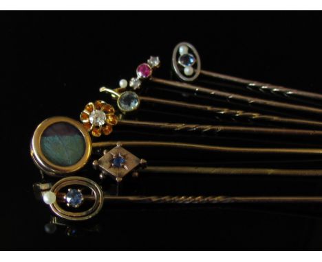 A bag containing seven assorted gold stick pins including diamond, sapphire and pearl etc