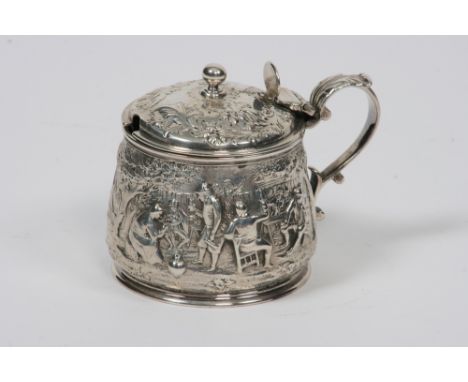 A George III silver mustard pot, with heavily embossed decoration of figures merrymaking in a rural landscape, the hinged dom