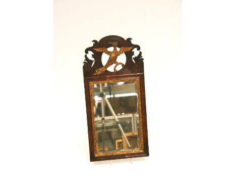 A mahogany Chippendale style wall mirror, having fret work pediment, decorated with a gilt bird, cushion frame and gilt slip 