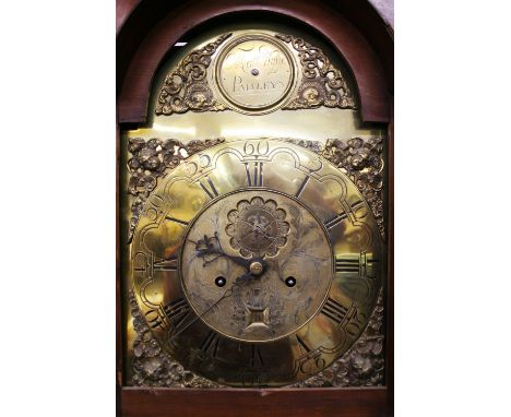 A George III mahogany and boxwood strung long case clock, the hood surmounted by a scrolled arch pediment, enclosing a brass 