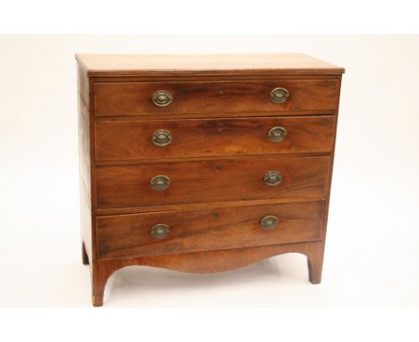 A Georgian mahogany and boxwood strung chest, of four long drawers, fitted brass drop handles and oval back plates, raised on
