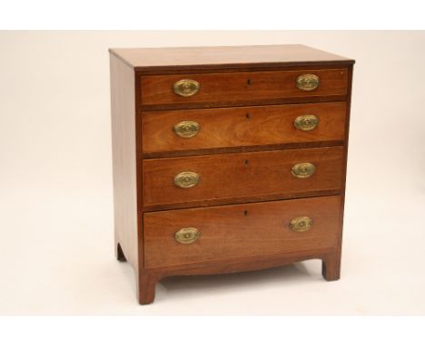 A George III mahogany and boxwood strung chest, fitted four long graduated drawers raised on shaped apron and bracket support
