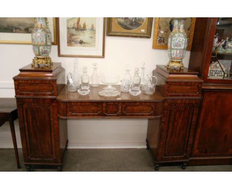 A George IV mahogany and rosewood cross-banded pedestal sideboard, the bow fronted central section fitted two drawers, flanke