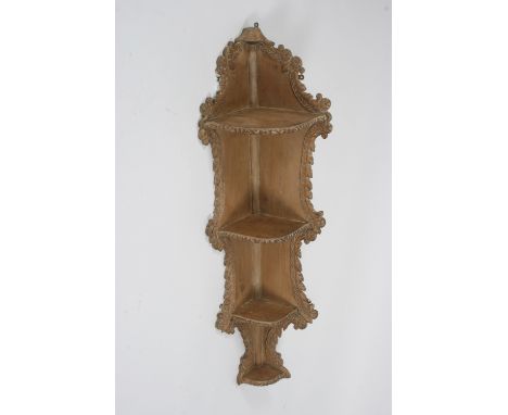 An 18th Century carved pine hanging corner shelf, with leaf decoration, 128cm high - see illustration