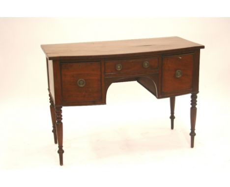 A 19th Century mahogany bow fronted sideboard, fitted central drawer above a shaped apron, flanked by deep drawers, raised on