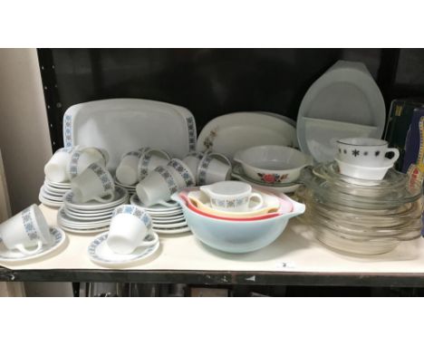 A shelf of 1970's Pyrex dinnerware and a shelf of plated cutlery etc. (2 shelves)