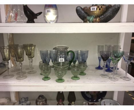 A shelf of coloured drinking glasses