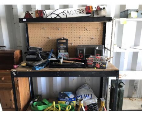 A metal framed work bench with backboard for tool hooks and an overhead shelf