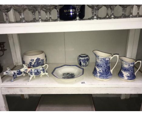 A shelf of blue &amp; white pottery including jugs, ginger jar &amp; cow creamer