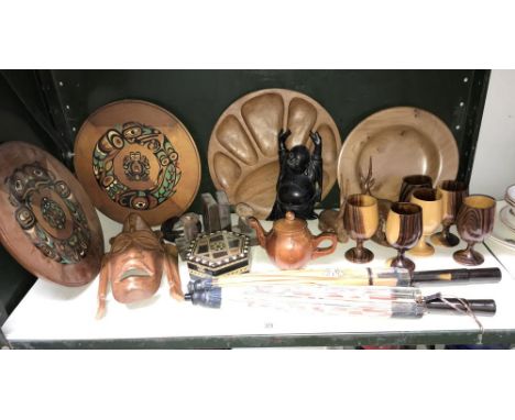 A shelf of wooden carved items including buddah, face mask etc.