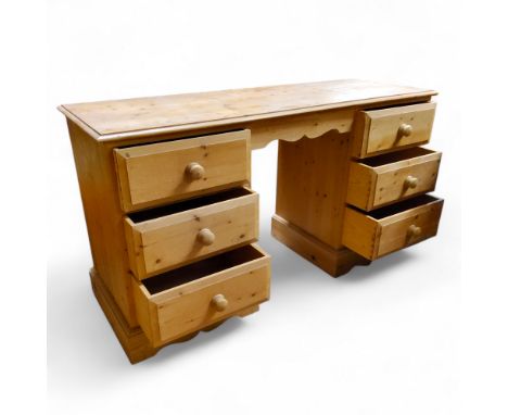 A pine pedestal kneehole desk, each pedestal holding three drawers, bracket feet, 75cm x 137cm x 48cm