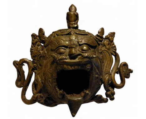 A 19th century Tibetan bronze Mahakala mask censer/incense burner, three feet, 16.5cm wide