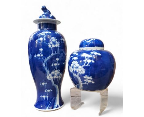 A Chinese Kangxi period baluster vase and cover, decorated in blue and white blossoming prunus; a similar ginger jar (2)