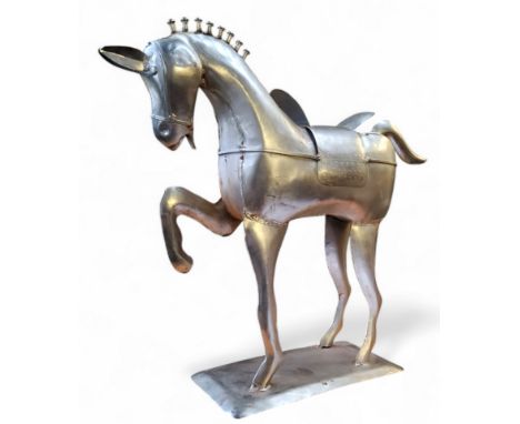 A decorative hammered metal sculpture of a prancing stallion, 48cm x 54cm