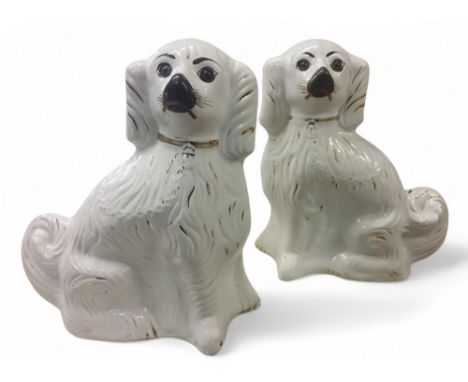 A pair of Staffordshire dogs, seated to the left and right, picked out in gilt, glass eyes, 34cnm high, late 19th century